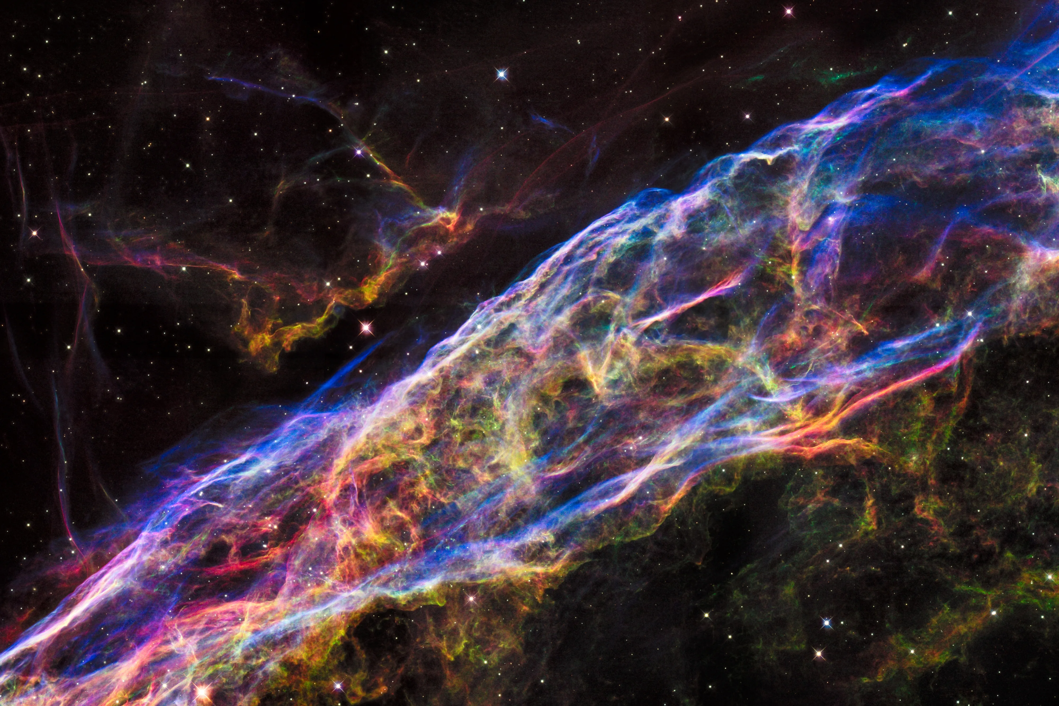 The Veil Nebula, imaged by the Hubble Space Telescope: luminous filaments of a supernova remnant against deep space.